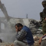 A Palestinian man cant look as his home is demolished